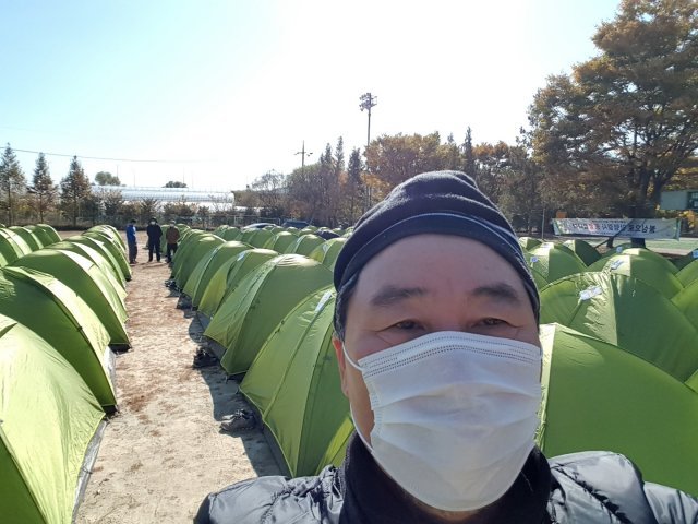 정충래 이사가 지난해 10월 열린 대구 동화사에서 서울 봉은사까지 511km 자비순례 도중 밤을 지내기 위해 줄지어 친 1인용 텐트를 배경으로 사진을 찍었다. 정충래 이사 제공.