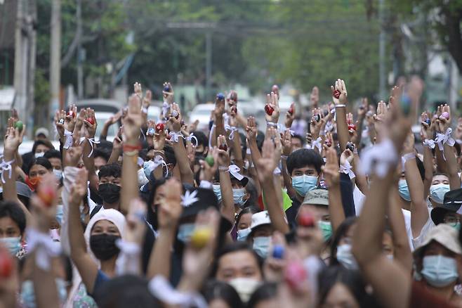 미얀마 최대 도시 양곤에서 4일 시위대가 색칠한 부활절 달걀을 쥐고 세 손가락 경례를 하며 군사 쿠데타에 대한 저항 의지를 표출하고 있다. AP/연합뉴스