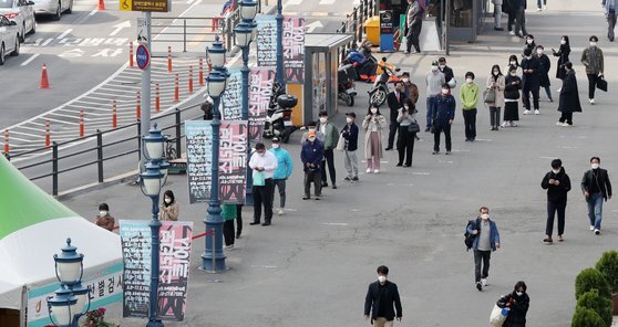6일 오전 서울역광장에 마련된 코로나19 임시선별검사소를 찾은 시민들이 길게 줄을 서 차례를 기다리고 있다. 뉴스1