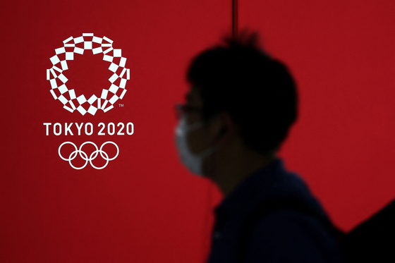 A pedestrian walks past a Tokyo 2020 Olympics logo in Japan Wednesday. Japanese Prime Minister Yoshihide Suga on Tuesday called North Korea's decision to skip the Tokyo Olympics a unilateral announcement. [AFP/YONHAP]