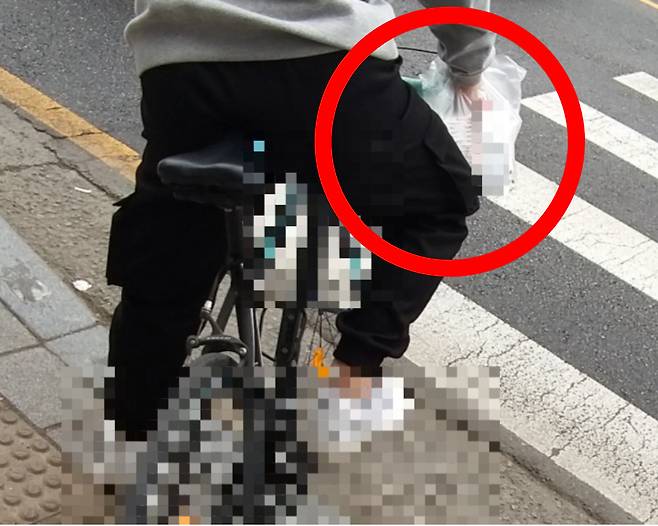 한 시민이 영수증이 붙어있는 음식 봉지를 별도의 배달가방 없이 자전거 손잡이에 걸어놓은 채 배달에 나서고 있다.[온라인 커뮤니티 갈무리]