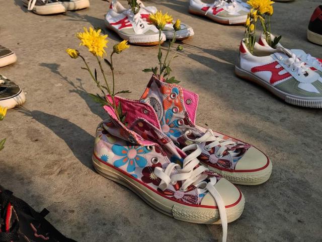 8일 미얀마 양곤 시민들이 반군부 시위 도중 사망한 이들을 기리기 위해 도로 위에 꽃을 꽂은 신발을 전시하고 있다. SNS 캡처