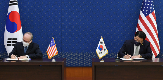 Korean First Vice Foreign Minister Choi Jong-kun, right, and Rob Rapson, charge d'affaires at the U.S. Embassy, formally sign the 11th Special Measures Agreement at the Foreign Ministry in central Seoul Thursday afternoon. [JOINT PRESS CORPS]