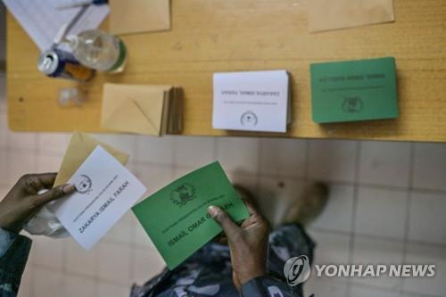 한 장교가 9일 지부티에서 투표전 대선후보 이름이 적힌 투표 카드를 들고 있다. [AFP=연합뉴스]