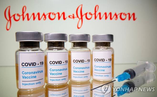 미국 제약사 존슨앤드존슨(J&J) 로고 앞에 신종 코로나바이러스 감염증(코로나19) 백신이라고 쓰인 병이 놓여있는 모습 [로이터=연합뉴스 자료사진]