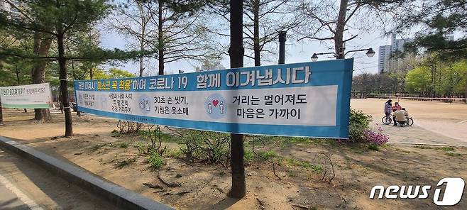 서울 동작구 보라매공원에 마스크 착용을 알리는 플래카드가 붙어있다. © 뉴스1
