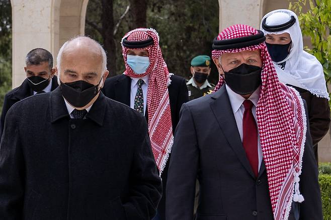 11일(현지 시각) 압둘라 2세(앞줄 오른쪽) 요르단 국왕이 암만에 있는 라가단궁으로 들어서고 있다. 가운데 하늘색 마스크 쓴 사람이 함자 왕자. /AFP 연합뉴스