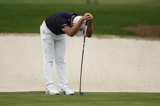 Kim Si-woo leans on the 3-wood that he had to use to putt after breaking his putter in a flash of rage during the second round of the Masters golf tournament on Friday in Augusta, Georgia. [AP/YONHAP]