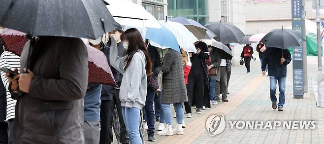 비가 와도 계속되는 검사행렬 (서울=연합뉴스) 김도훈 기자 = 12일 오후 서울 중랑구 보건소에 마련된 코로나19 임시선별진료소를 찾은 시민들이 우산을 쓰고 순서를 기다리고 있다. 2021.4.12 superdoo82@yna.co.kr