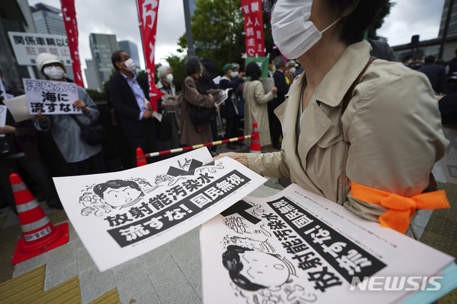[도쿄=AP/뉴시스]13일 일본 도쿄의 총리관저 밖에서 후쿠시마 원전 오염수 해양 방류에 반대하는 시민들이 "방사능 오염수를 바다에 버리지 말라"라고 쓰인 전단을 나눠주고 있다.  일본 정부는 지역 어민과 주민들의 반대 속에 후쿠시마 원전에서 나온 대량의 방사능 오염수를 2년 후에 태평양으로 방류하기로 했다. 2021.04.13.