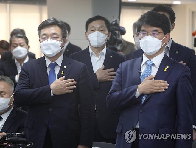 국기에 대한 경례하는 윤호중과 박완주 (서울=연합뉴스) 하사헌 기자 = 더불어민주당 윤호중(왼쪽), 박완주 원내대표 후보자가 13일 서울 여의도 민주당 중앙당사에서 열린 제21대 국회 제2기 더불어민주당 원내대표 후보자 합동토론회에서 국기에 대한 경례를 하고 있다. 2021.4.13 toadboy@yna.co.kr