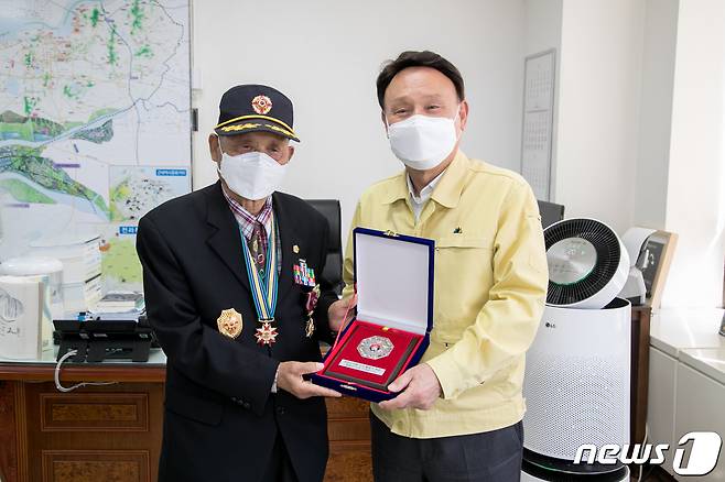 강임준 군산시장(사진 왼쪽)이 6·25전쟁 참전용사인 강영구씨에게 무공훈장을 전달하고 있다.© 뉴스1