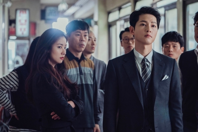 tvN 드라마 '빈센조'의 주인공을 맡은 배우 송중기(앞줄 오른쪽)와 전여빈(앞줄 왼쪽)이 '금가프라자' 사람들과 함께 있는 장면. CJ ENM 제공