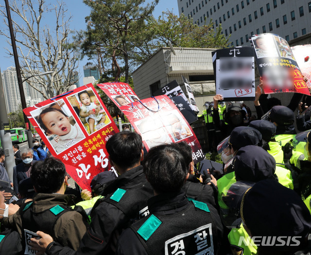 [서울=뉴시스]박주성 기자 = 양부모의 학대 끝에 숨진 16개월 된 입양 딸 '정인이'의 양부모의 결심 공판이 열린 지난 14일 오후 서울 양천구 서울남부지방법원 입구에서 시민들이 양모가 탑승한 것으로 보이는 호송차를 향해 팻말을 들고 항의하고 있다. 2021.04.14. park7691@newsis.com