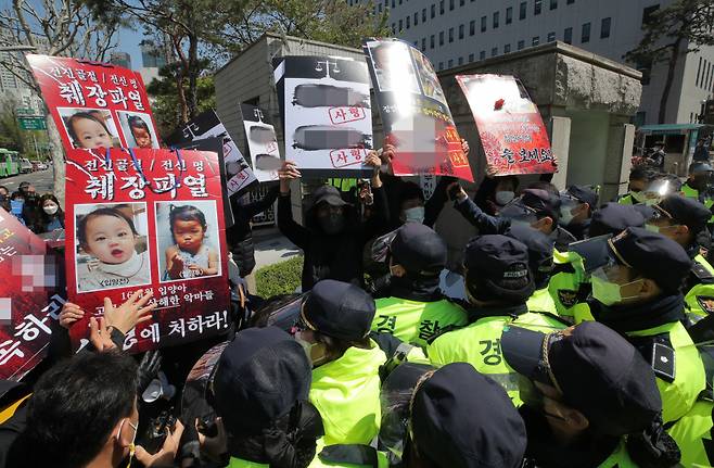 16개월 된 입양 딸 정인양을 학대해 숨지게 한 혐의를 받는 양부모의 결심 공판이 열린 4월14일 오후 서울 양천구 서울남부지방법원 입구에서 시민들이 양모가 탑승한 것으로 보이는 호송차를 향해 팻말을 들고 항의하고 있다. ⓒ 연합뉴스