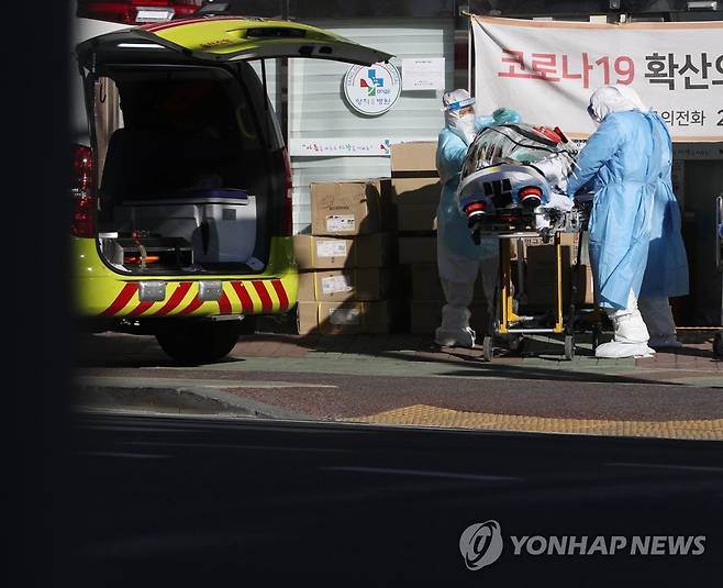 지난해 12월 17일 오후 울산시 남구 양지요양병원 앞에서 신종 코로나바이러스 감염증(코로나19)에 확진된 환자가 의료진과 119구급대원들에 의해 구급차로 옮겨지고 있다. [연합뉴스 자료사진]