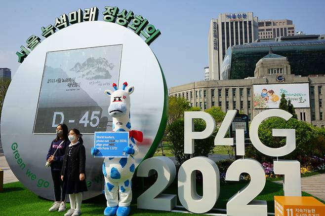 Kirini the blue-spotted giraffe holds up a sign in front of City Hall in central Seoul, calling on leaders to phase out coal by 2030 and keep their commitments under the Paris Agreement. (Korea Beyond Coal)