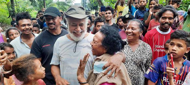 샤나나 구스망 전 동티모르 대통령이 홍수 피해 현장에서 복구 작업을 하던 중 시민들과 어깨동무를 한 채 웃고 있다.페이스북 캡처