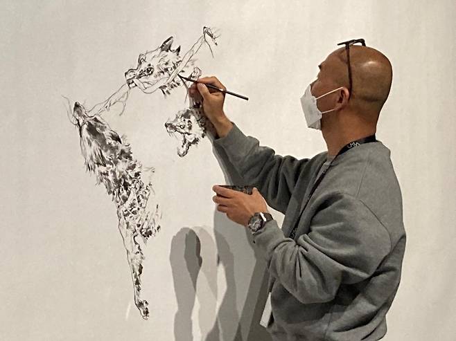 (서울=연합뉴스) 강종훈 기자 = 김정기 작가가 롯데뮤지엄 '디 아더 사이드' 전에서 라이브 드로잉을 선보이고 있다.