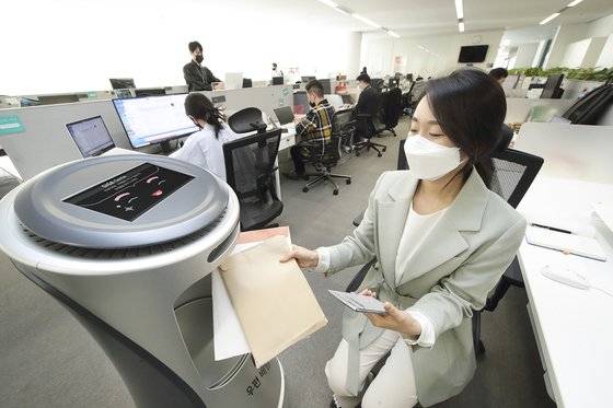KT 광화문빌딩에 근무하는 직원들이 KT AI 로봇을 활용한 우편배송 서비스를 체험하고 있다. KT 제공