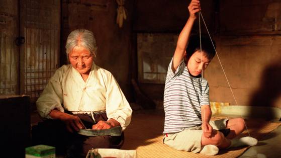 A scene from the 2002 film ″The Way Home″ which shows Kim Eul-boon, left, playing the role of the mute grandmother in the remote countryside, and Yoo Seung-ho playing her grandson from a metropolitan city. [CJ ENTERTAINMENT]