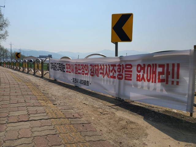 20일 경기 포천의 한 골프장 진입 도로 옆에 골프장의 영업행태를 비판하는 현수막이 내걸려 있다. 이종구 기자