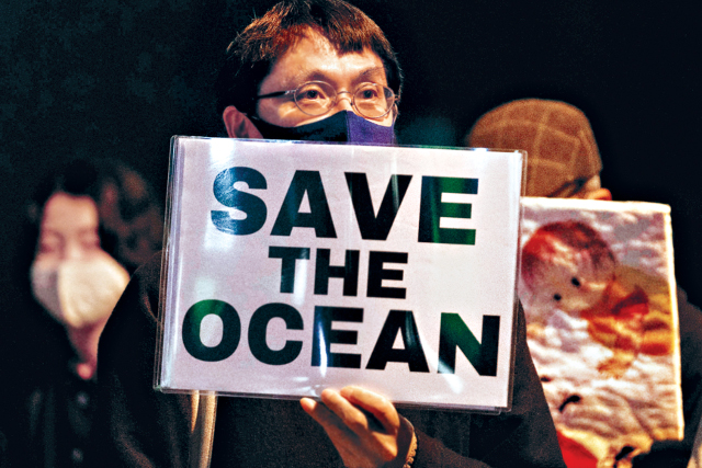 일본 정부의 후쿠시마 원전 오염수 해상 방류를 반대하는 시위에 참석한 한 일본인이 지난 13일 도쿄의 총리 관저 앞에서 ‘바다를 살리라’는 내용의 피켓을 들고 있다. 연합뉴스