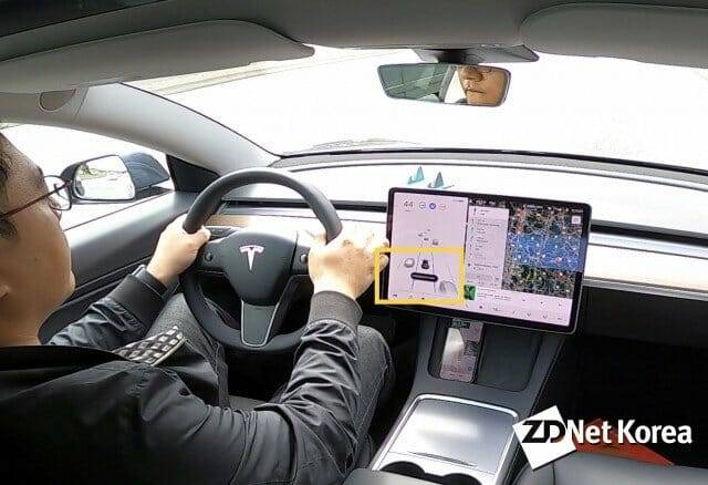 기초적인 오토파일럿이 실행된 테슬라 모델 3 주행 모습. 오토파일럿이 실행되면 항상 스티어링 휠을 잡고 있으라는 안내 메세지가 등장한다(노란색 네모 안).