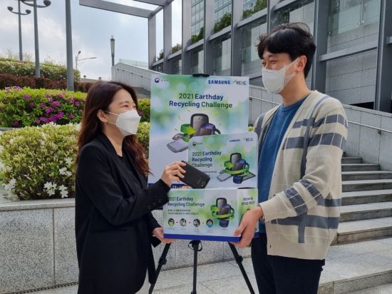 삼성전자 수원사업장(삼성디지털시티)에서 임직원들이 폐휴대폰 수거 캠페인을 독려하는 모습(사진제공=삼성전자)