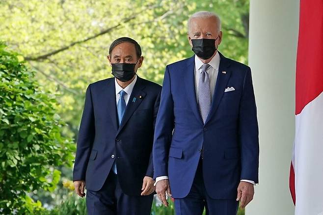 조 바이든 미국 대통령과 스가 요시히데 일본 총리가 지난 16일 백악관 로즈가든에서 열린 공동기자회견에 참석하기 위해 걸어가고 있다. 워싱턴/AFP 연합뉴스