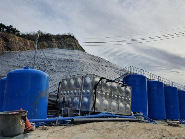 1일 전북 완주 비봉면 폐석산 앞에 침출수를 담는 파란색 드럼통들과 간이 폐수 처리장이 세워져 있다. 이정원 기자