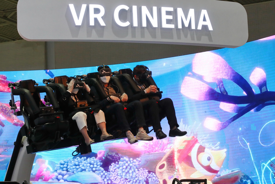 Visitors to the World IT Show experience virtual reality (VR) cinema at SK Telecom's booth in Coex, southern Seoul on Wednesday. The event will run until April 23. [YONHAP]