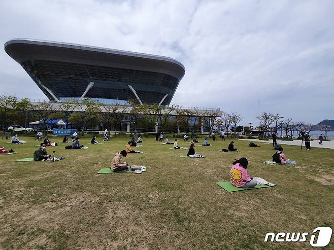 국립해양박물관 앞 정원에서 '海(해)멍海(해)몽 행사 참가자들이 앉아 바다를 보며 명상을 하고 있다.2021.4.21/© 뉴스1 손연우 기자