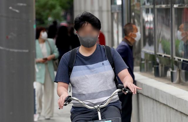 낮 기온이 최고 28도까지 오르는 등 초여름 날씨가 예보된 22일 오전 서울 종로구 광화문네거리에서 한 시민이 반팔 옷을 입고 출근하고 있다. 뉴시스