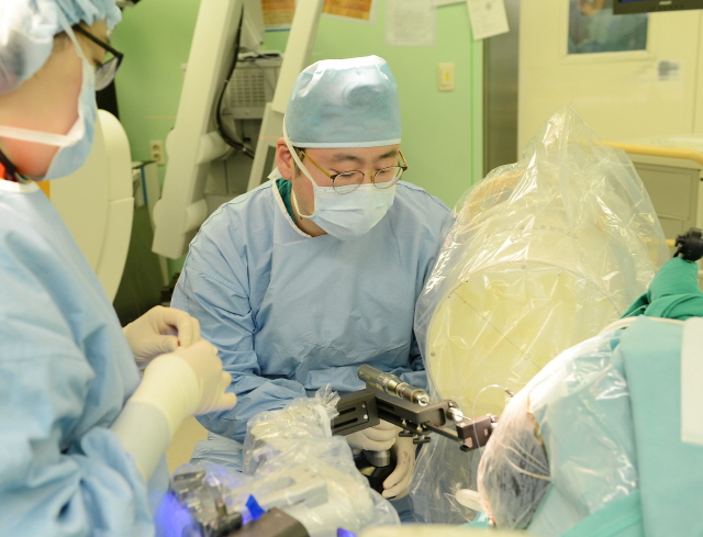 장원석 교수가 국내 최초로 개발된 뇌수술 보조 로봇장비인 카이메로를 이용해 환자의 뇌심부에 전극을 삽입하고 있다. 카이메로를 이용한 뇌전증 수술은 약 2~3mm의 작은 구멍으로 전극을 삽입할 수 있어 수술시간도 짧고, 부작용이나 수술 후 통증도 줄일 수 있다./세브란스 제공