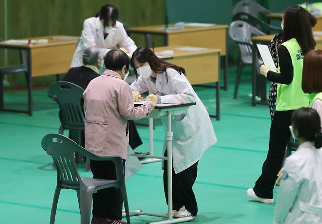 Health care workers on Monday examine people prior to vaccination at a center in Gwangju. (Yonhap)