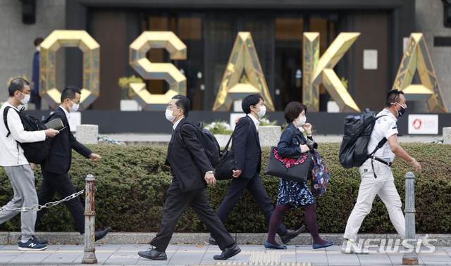 [오사카=AP/뉴시스]5일 일본 오사카에서 코로나19 확산을 막기 위해 마스크를 쓴 사람들이 길을 걸어가고 있다. 2021.04.05.