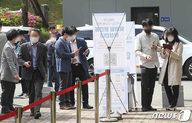 23일 서울 관악구 서울대학교 자연과학대학 앞에 마련된 코로나19 신속분자진단검사소에서 교직원들이 코로나19 신속진단 검사를 받기 위해 모바일 문진표를 작성하고 있다. 2021.4.23/뉴스1 © News1 임세영 기자