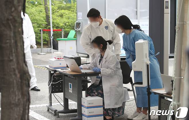 23일 서울 관악구 서울대학교 자연과학대학 앞에 마련된 코로나19 신속분자진단검사소에서 관계자들이 코로나19 신속진단 검사를 준비하고 있다. 2021.4.23/뉴스1 © News1 임세영 기자