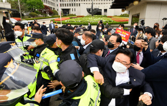 국민의힘 소속 의원들이 23일 오전 김명수 대법원장이 탄 관용차를 막아서려고 경찰과 몸싸움을 벌이고 있다. 연합뉴스