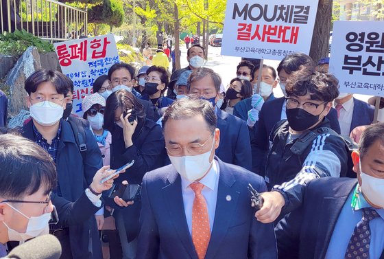 통합을 위한 양해각서(MOU) 체결을 위해 19일 부산교대를 방문한 차정인 부산대 총장이 부산교대 총동창회 회원들의 반대로 되돌아가고 있는 모습. 결국 양 학교 간 서면 교환으로 양해각서가 체결됐다. 연합뉴스