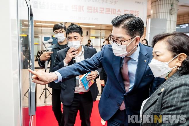 이정훈 강동구청장이 자판기 형태의 무인 도서대출기인 ‘스마트도서관’의 사용방법을 주민에게 설명하고 있다.