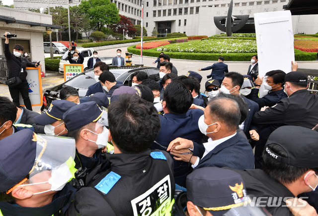 [서울=뉴시스]국회사진기자단 = 주호영 국민의힘 당 대표 권한대행과 당 의원들이 23일 오전 서울 서초구 대법원 정문 앞에서 김명수 대법원장의 사퇴 촉구 공동선언 기자회견을 한 뒤 김 대법원장이 탄 차량에 항의를 하고 있다. 2021.04.23. photo@newsis.com