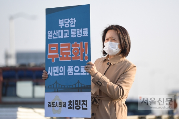 최명진 김포시의원이 일산대교 통행료 무료화 피켓 시위를 벌이고 있는 모습.