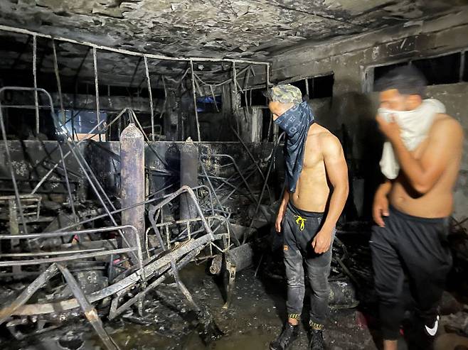 이라크 민방위군 관계자들이 24일(현지시간) 바그다드 이븐 알하티브 병원의 화재 사고 현장을 살펴보고 있다. 바그다드 | 로이터연합뉴스