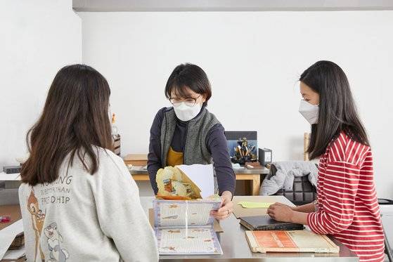 재영책수선의 재영(가운데)이 소중 학생기자단이 가져온 책을 함께 살펴보며 왜 망가졌고 어떻게 고칠지 진단하고 있다.