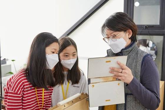 장채원 학생기자가 가져온 아버지의 전공서적 커버를 분리해 책등 부분에 있는 거즈면과 낡은 면지를 확인하고 있다.