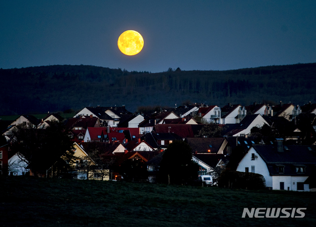 [프랑크푸르트=AP/뉴시스]26일(현지시간) 독일 프랑크푸르트 인근 오베른하인 마을 상공에 보름달이 두둥실 솟아올라 있다. 2021.04.26.