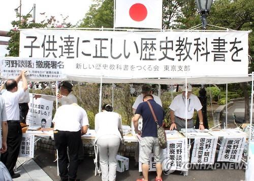 우익 단체인 '새로운 역사 교과서를 만드는 모임'이 2015년 8월 15일 오전 일본 도쿄도(東京都) 지요다(千代田)구 야스쿠니(靖國)신사 인근에서 '아이들에게 올바른 역사 교과서를'이라는 현수막을 걸고 서명운동을 하고 있다. 왼쪽에서 한 남성이 '고노담화 철폐 서명'을 알리는 표지를 붙이고 있다. [연합뉴스 자료사진]