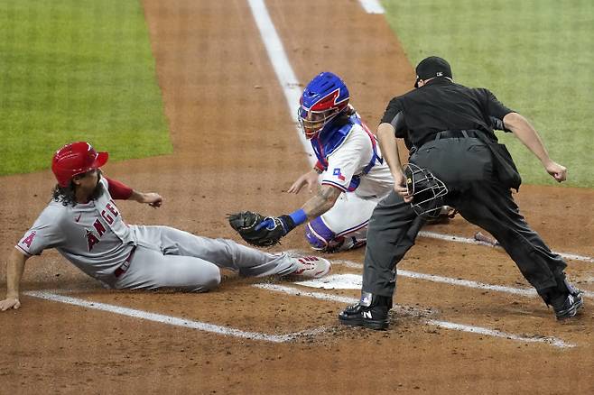 <YONHAP PHOTO-2021> Los Angeles Angels‘ Anthony Rendon reaches the plate ahead of the attempted tag by Texas Rangers catcher Jonah Heim as umpire Brian O’Nora looks on in the first inning of a baseball game in Arlington, Texas, Wednesday, April 28, 2021. Rendon and Jared Walsh scored on a Jos? Iglesias single. (AP Photo/Tony Gutierrez)/2021-04-29 09:52:32/<저작권자 ⓒ 1980-2021 ㈜연합뉴스. 무단 전재 재배포 금지.>